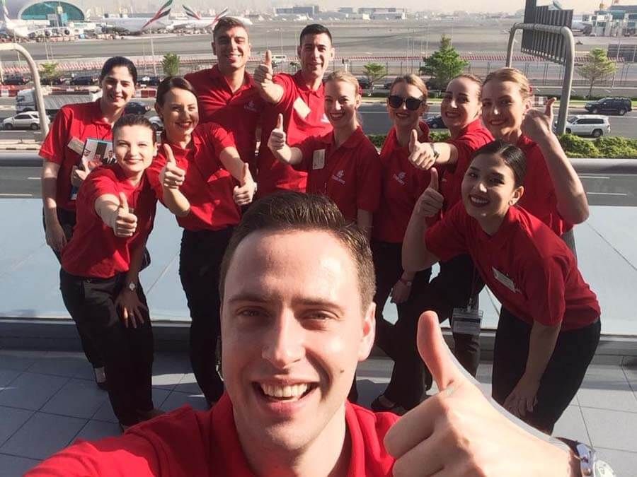 Nuevos cabin crew Emirates con camisetas rojas de formación antes de las clases en Emirates Aviation College.